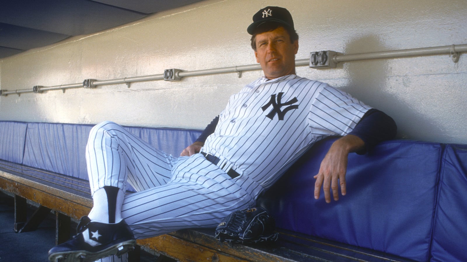 Tommy John #25 of the New York Yankees looks on from the dugout prior to the start of a Major League Baseball game circa 1987 at Yankee Stadium in the Bronx.