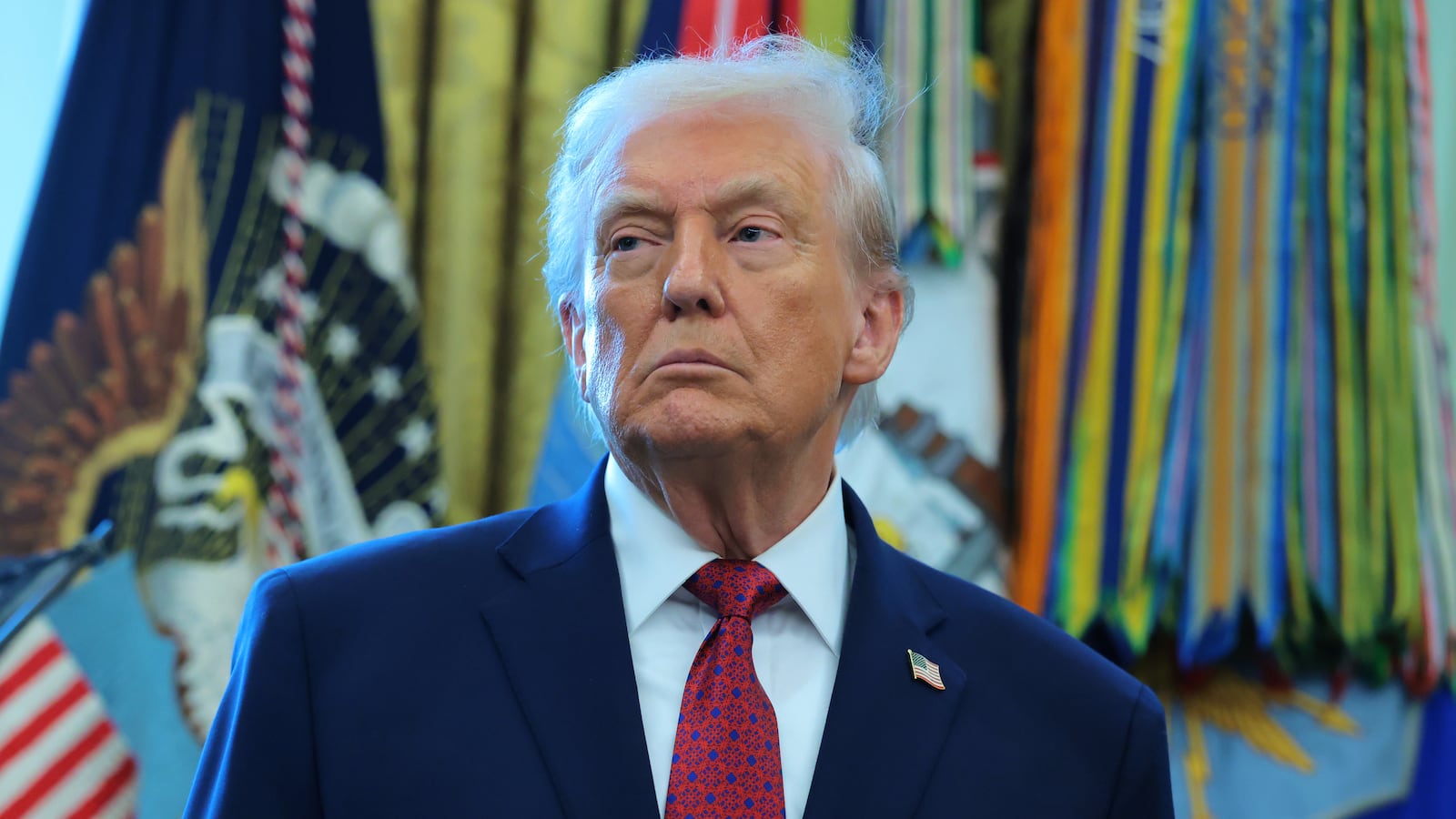 U.S. President Donald Trump listens during a ceremony for the presentation of the Mexican Border Defense Medal in the Oval Office of the White House on December 15, 2025 in Washington, DC.