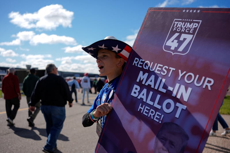 A person holds a sign asking people to request their mail-in ballot, on the day of Republican presidential nominee and former U.S. President Donald Trump's rally, in Mosinee, Wisconsin, U.S. September 7, 2024. REUTERS/Brian Snyder