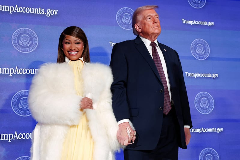 U.S. President Donald Trump and musician Nicki Minaj hold hands onstage at the U.S. Treasury Department's Trump Accounts Summit, in Washington, D.C., U.S. January 28, 2026. REUTERS/Kevin Lamarque     TPX IMAGES OF THE DAY