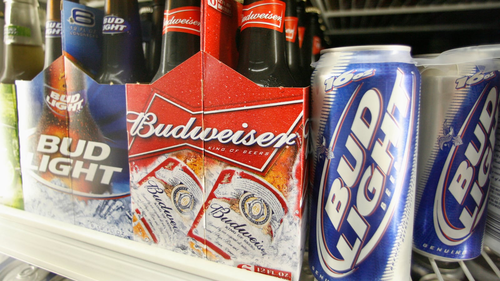 Bud Light and Budweiser sit on a cooler shelf.