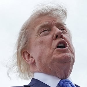 U.S. President Donald Trump holds a printed-out article as he speaks to the members of the media after disembarking Marine One, before boarding Air Force One, en route to John F. Kennedy International Airport, at Joint Base Andrews, Maryland, U.S., August 14, 2026. REUTERS/Ken Cedeno