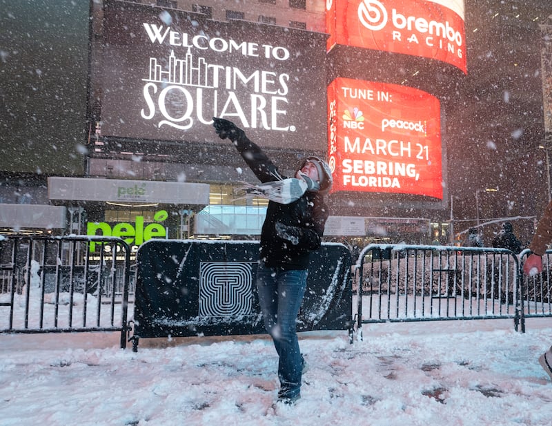 NEW YORK, NEW YORK - FEBRUARY 22: A person throws a snow ball in Times Square on February 22, 2026 in New York, New York. The northeast U.S. is bracing for an intense nor'easter with blizzard conditions, heavy snow, and strong winds. (Photo by Noam Galai/Getty Images)