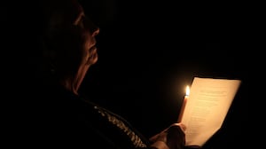 PASADENA, CALIFORNIA - DECEMBER 24: A worshipper holds a candle during a special Christmas Eve community service at Westminster Presbyterian Church, adjacent to the Eaton Fire burn zone, on December 24, 2025 in Pasadena, California. The ecumenical service was held in partnership with LIFT International Church of Altadena and Altadena Community Church, whose sanctuary was destroyed in the Eaton Fire. (Photo by )