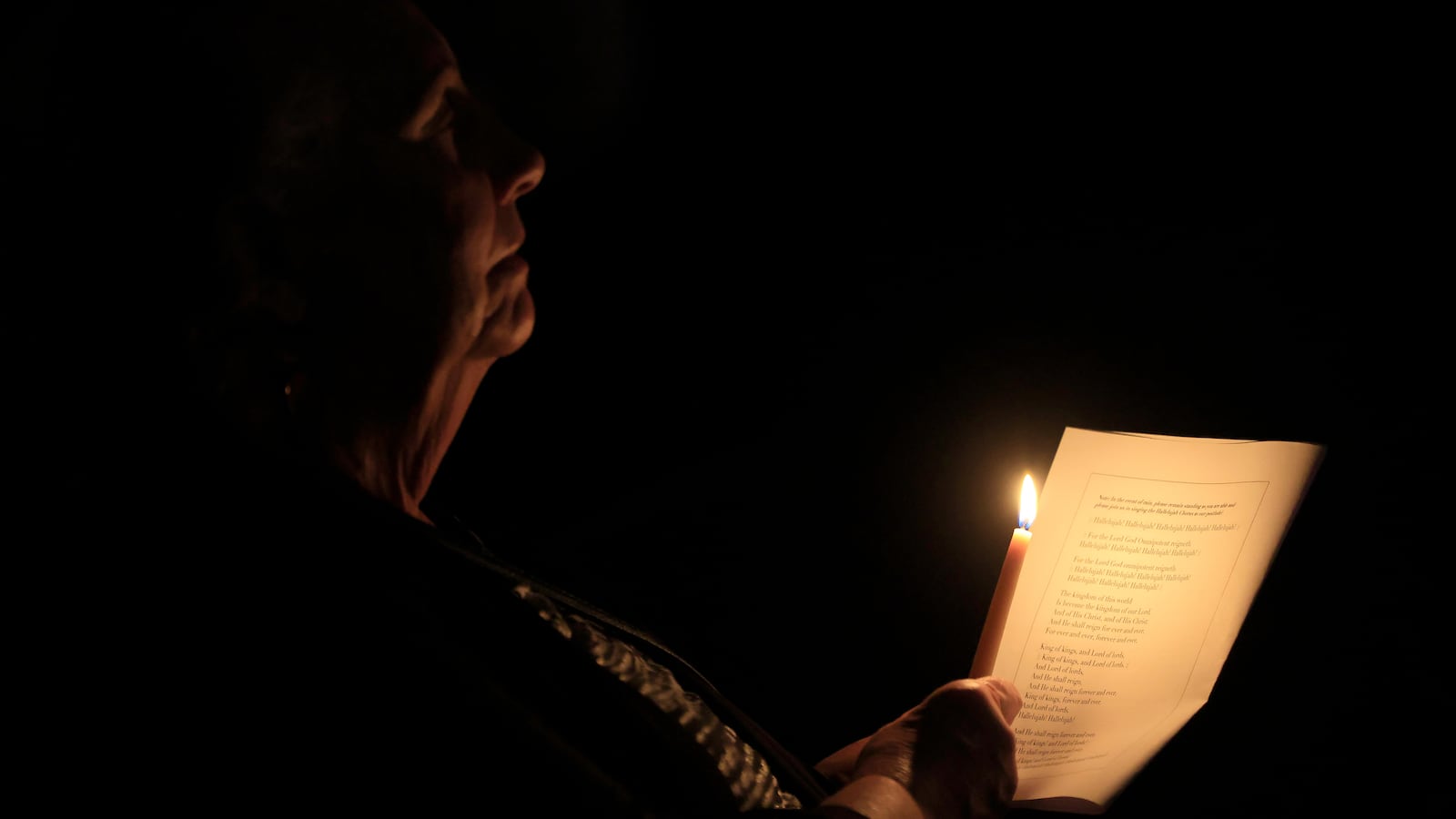 PASADENA, CALIFORNIA - DECEMBER 24: A worshipper holds a candle during a special Christmas Eve community service at Westminster Presbyterian Church, adjacent to the Eaton Fire burn zone, on December 24, 2025 in Pasadena, California. The ecumenical service was held in partnership with LIFT International Church of Altadena and Altadena Community Church, whose sanctuary was destroyed in the Eaton Fire. (Photo by )