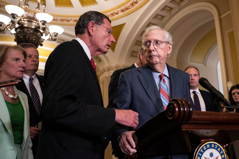 Senator John Barrasso (R-WY) reaches out to help then-Senate Minority Leader Mitch McConnell after McConnell froze and stopped talking at the microphones during a news conference after a lunch meeting with Senate Republicans U.S. Capitol 26, 2023 in Washington, DC.