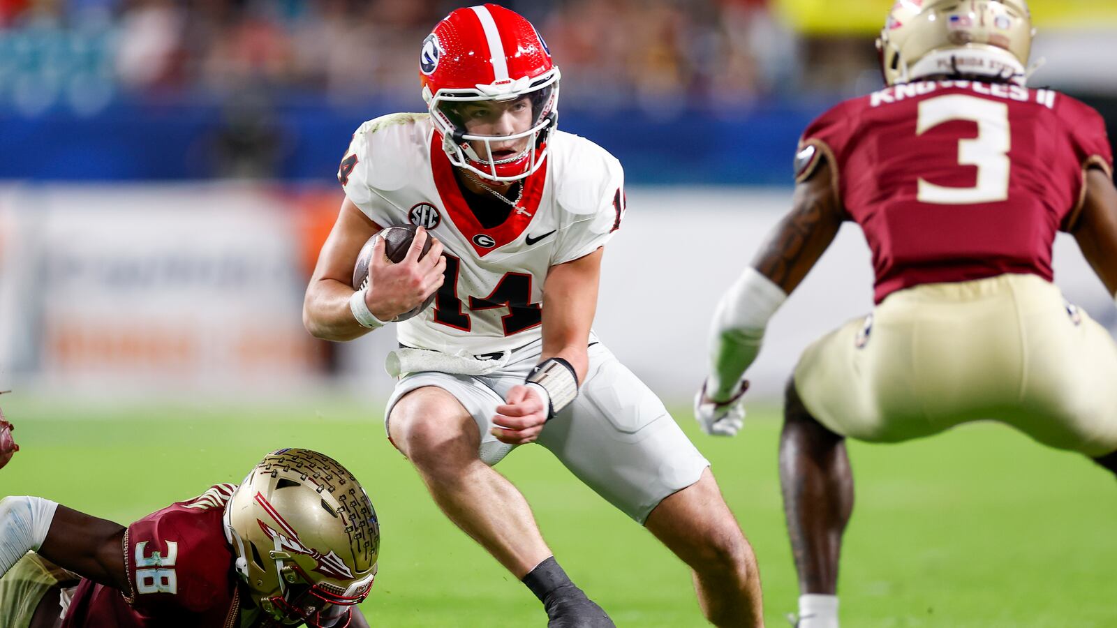Georgia Bulldogs quarterback Gunner Stockton (14) runs with the ball during the game between the Georgia Bulldogs and the Florida State Seminoles on December 30, 2023.