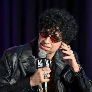 Sebastian Chacon holds a microphone while speaking on stage at an event. 