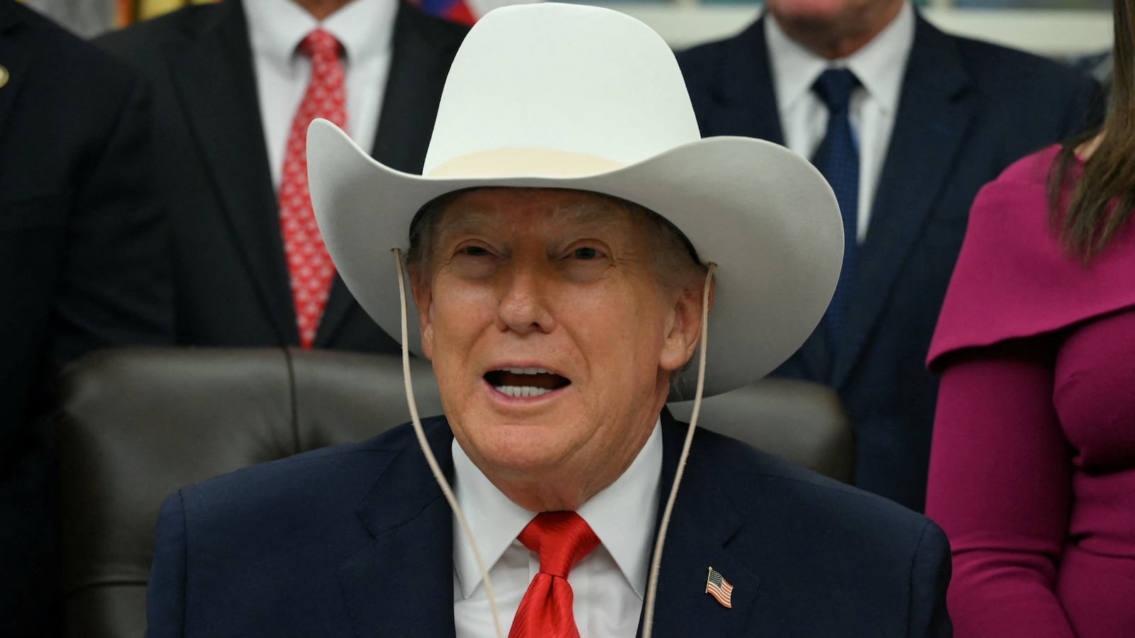 TOPSHOT - US President Donald Trump wears a cowboy hat during a bill signing ceremony with members of the 1980 US Olympic men's ice hockey team in the Oval Office of the White House in Washington, DC, on December 12, 2025. The legislation will award all of the players with Congressional Gold Medals to recognize the 45th anniversary of the US victory at the 1980 Winter Olympic Games. (Photo by Jim WATSON / AFP via Getty Images)