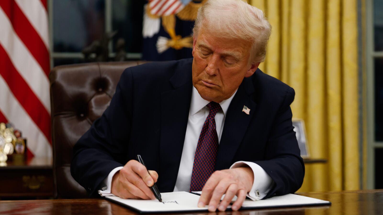 President Donald Trump signs executive orders in the Oval Office of the White House on January 20, 2025 in Washington, DC.