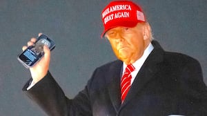 President Donald Trump disembarks from Air Force One while holding his cellphone at Joint Base Andrews in Maryland, May 30, 2025.