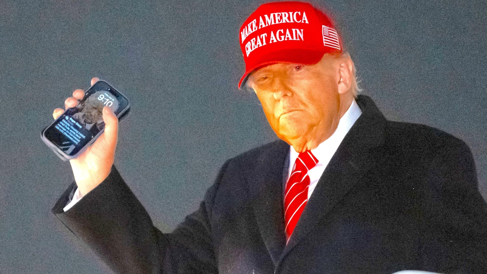 President Donald Trump disembarks from Air Force One while holding his cellphone at Joint Base Andrews in Maryland, May 30, 2025.