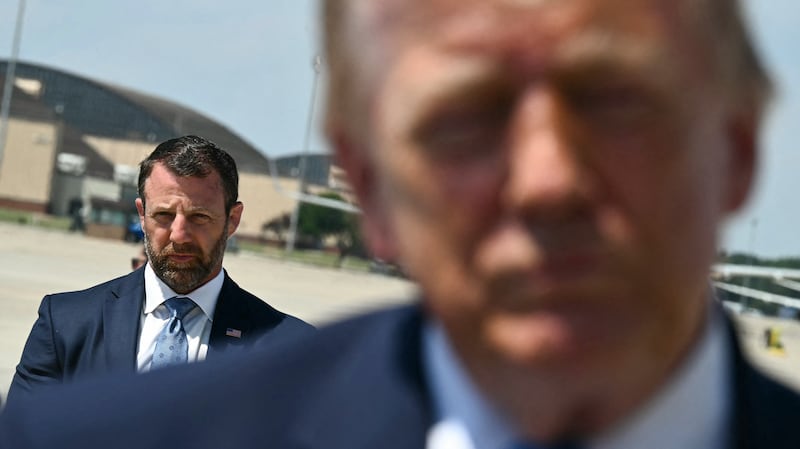 US Secretary of Homeland Security Markwayne Mullin looks on as President Donald Trump speaks to reporters after stepping off Air Force One.