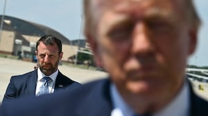 US Secretary of Homeland Security Markwayne Mullin looks on as President Donald Trump speaks to reporters after stepping off Air Force One.