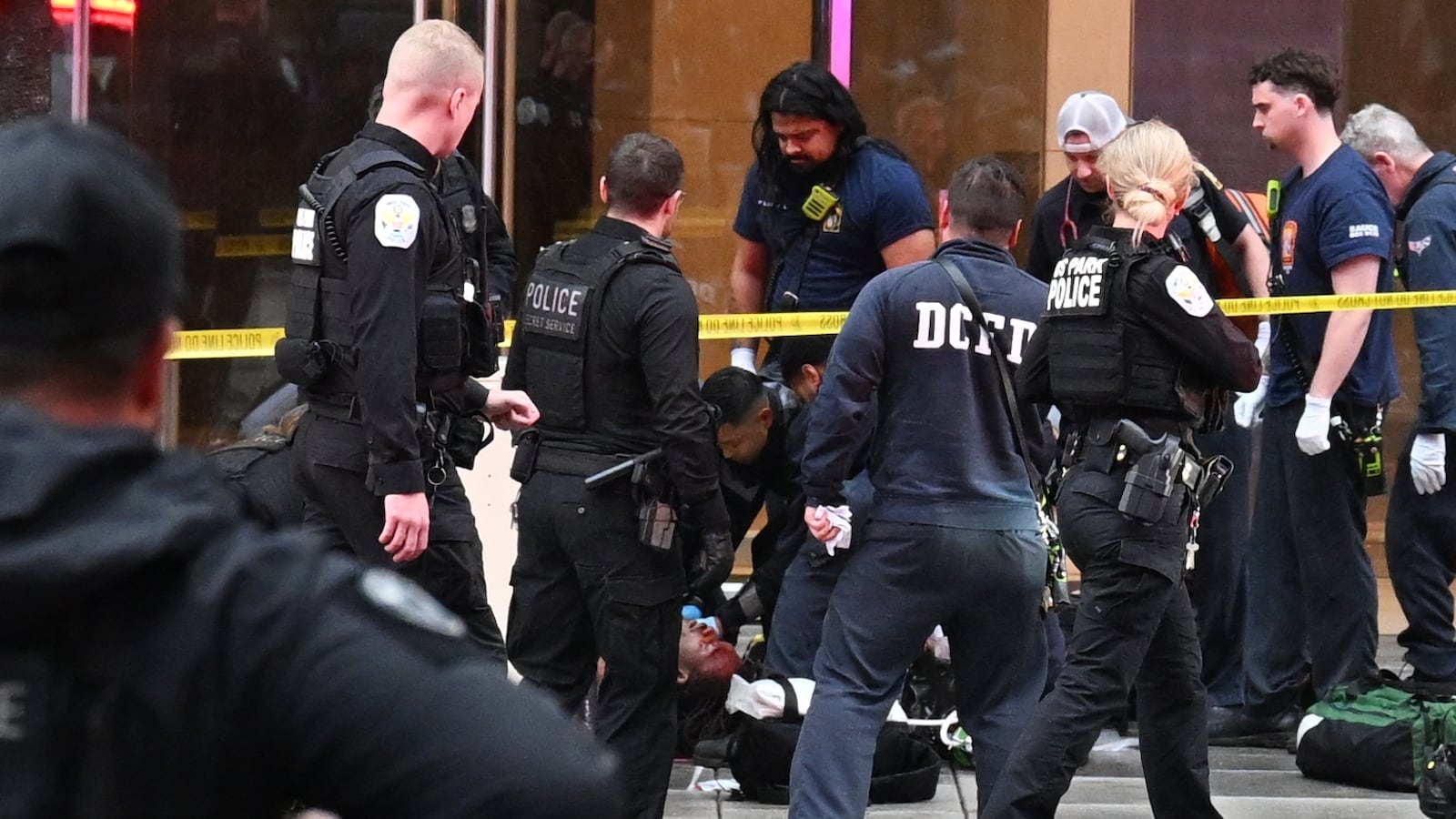 Members of the U.S. Secret Service tend to a wounded man on the scene of a shooting near the White House on May 23, 2026 in Washington, DC. Emergency teams work the scene after multiple rapid-fire gunshots ring out outside the White House.