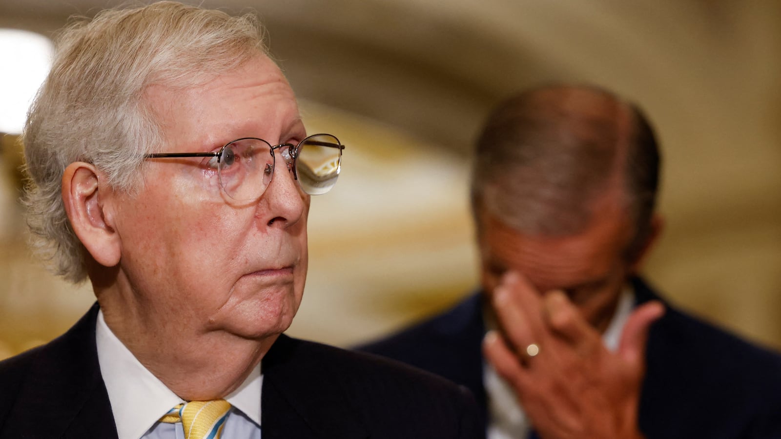 Mitch McConnell, wearing a suit, stares to the side during a press conference he failed to finish after he froze mid-way through.