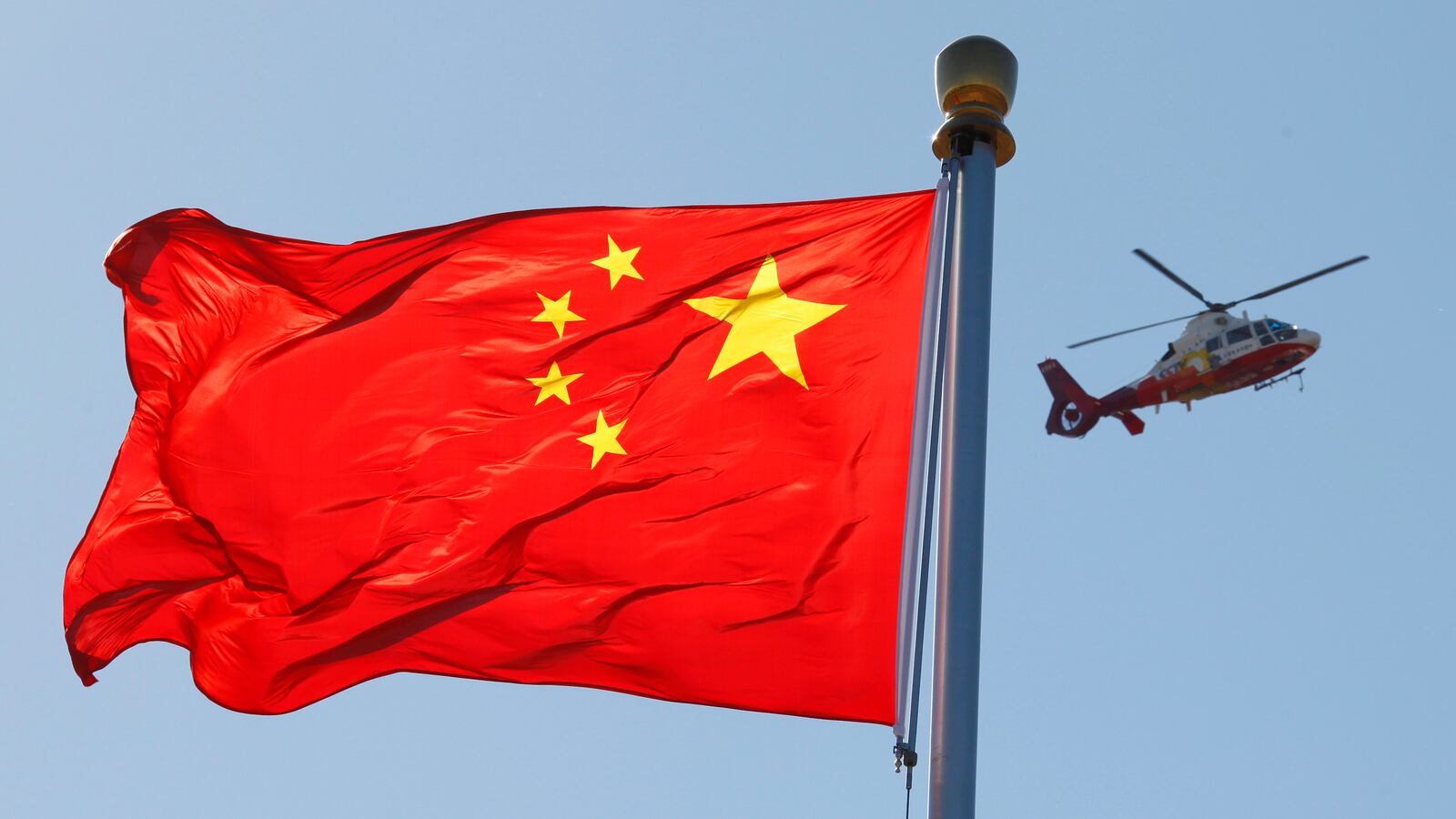 A China Central Television (CCTV) helicopter flies over the Chinese national flag in Tiananmen Square October 9, 2012.