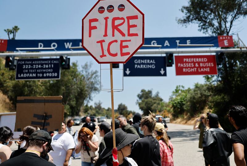 Protesters demonstrate not far from federal agents staged outside a gate of Dodger Stadium