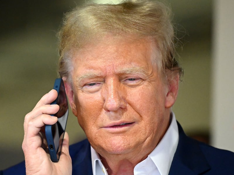 MIAMI, FLORIDA - MAY 05: Donald Trump talks on the phone in the McLaren garage prior to the F1 Grand Prix of Miami at Miami International Autodrome on May 05, 2024 in Miami, Florida. (Photo by Clive Mason/Getty Images)
