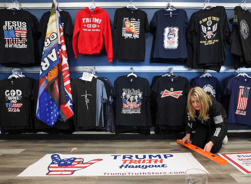 Lisa Fleischmann measures a Trump sign to install on the wall in her store, the Trump Truth Store and Hangout, on Jan. 13, 2026, in Crystal Lake. (Stacey Wescott/Chicago Tribune/Tribune News Service via Getty Images)