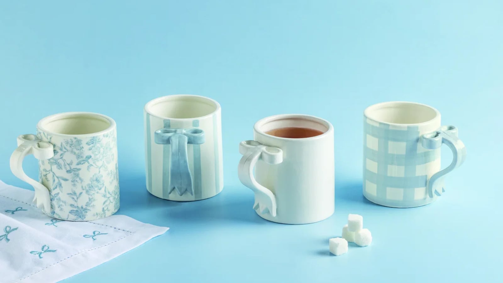 Selection of mugs from Mud Pie in front of a blue background