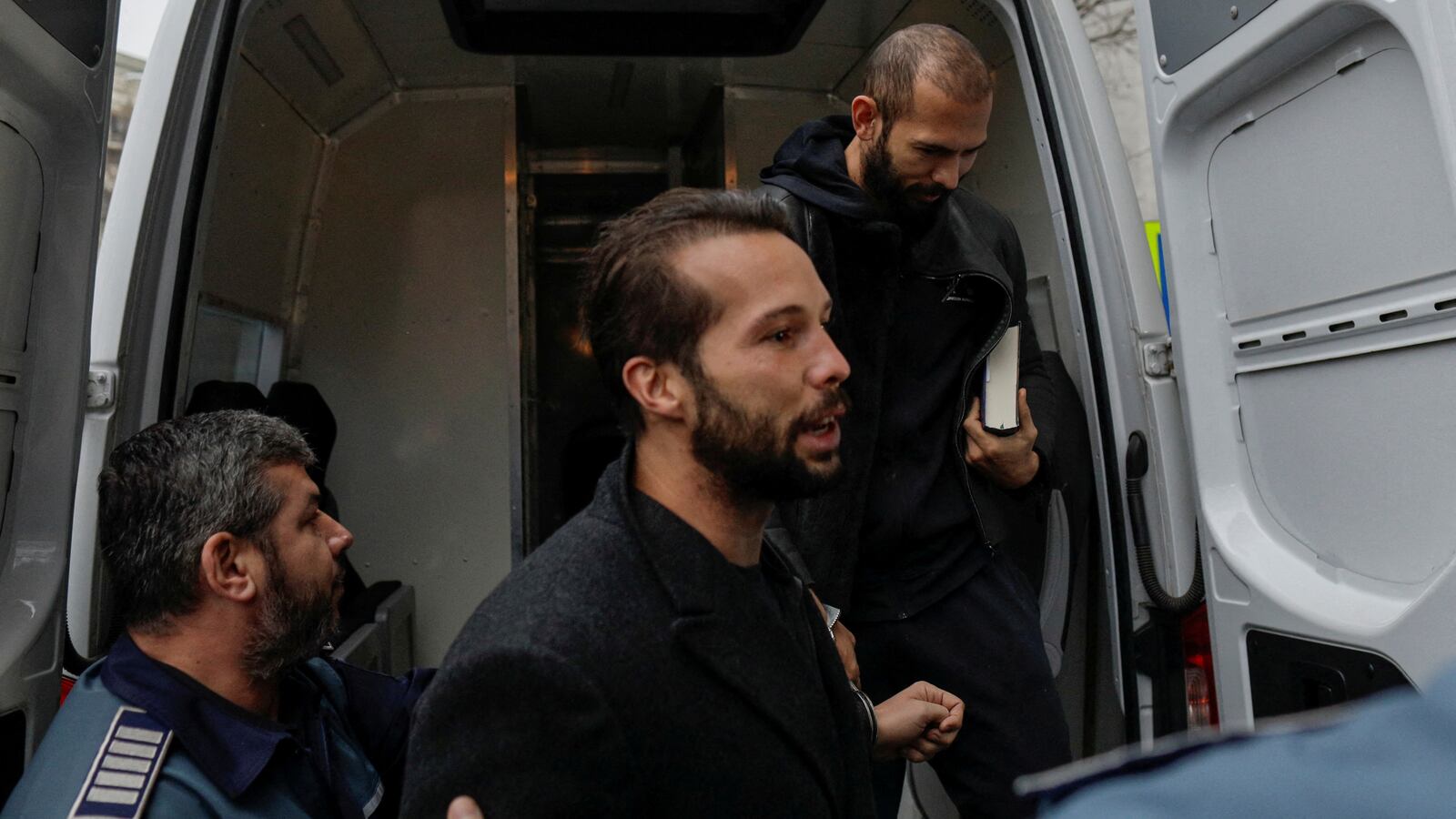 Tristan and Andrew Tate are brought in for questioning in Bucharest, Romania, on Jan. 26, 2023.