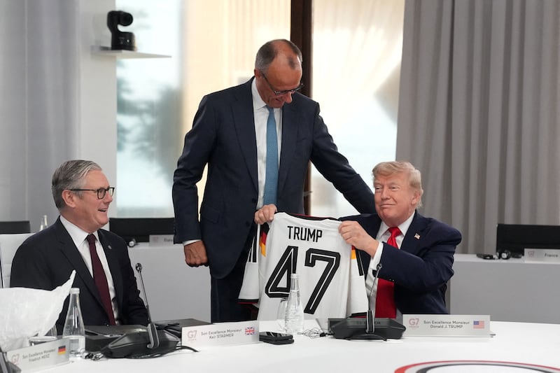 German Chancellor Friedrich Merz presents U.S. President Donald Trump, with a jersey with the number 47 on it during a working session at the G7 summit in Evian-les-Bains, France, June 16, 2026.     Thibault Camus/Pool via REUTERS