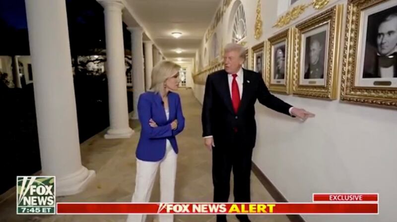 Donald Trump points to where his new presidential plaques will be mounted.