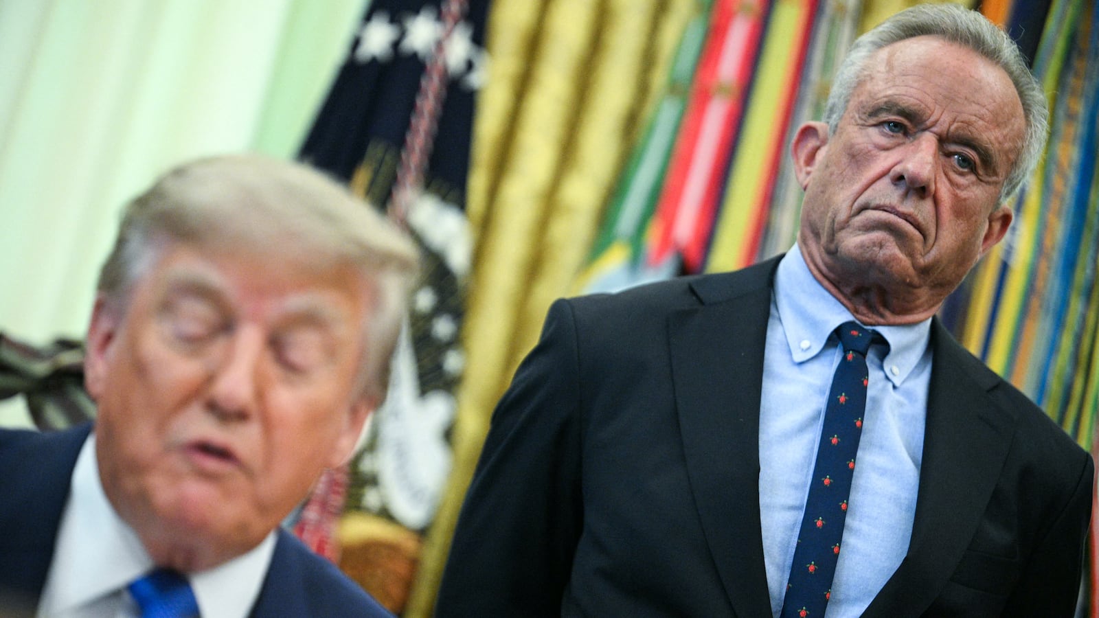 U.S. Secretary of Health and Human Services Robert F. Kennedy Jr. (R) looks on as President Donald Trump speaks before signing an executive order calling for more research and flexibility on vaccines.