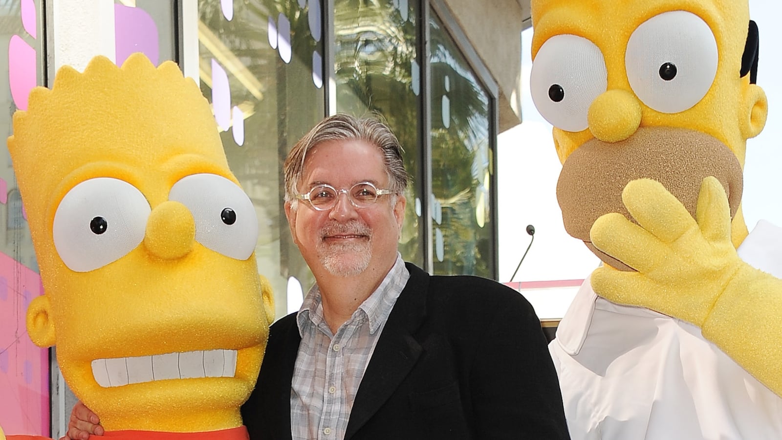 Matt Groening, creator of "The Simpsons," poses with his characters Bart (L) and Homer Simpson