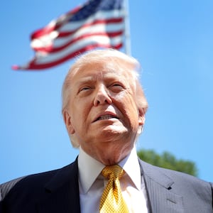 President Donald Trump speaks in front of the American flag to the press as he departs the White House on May 12, 2026 in Washington, DC.
