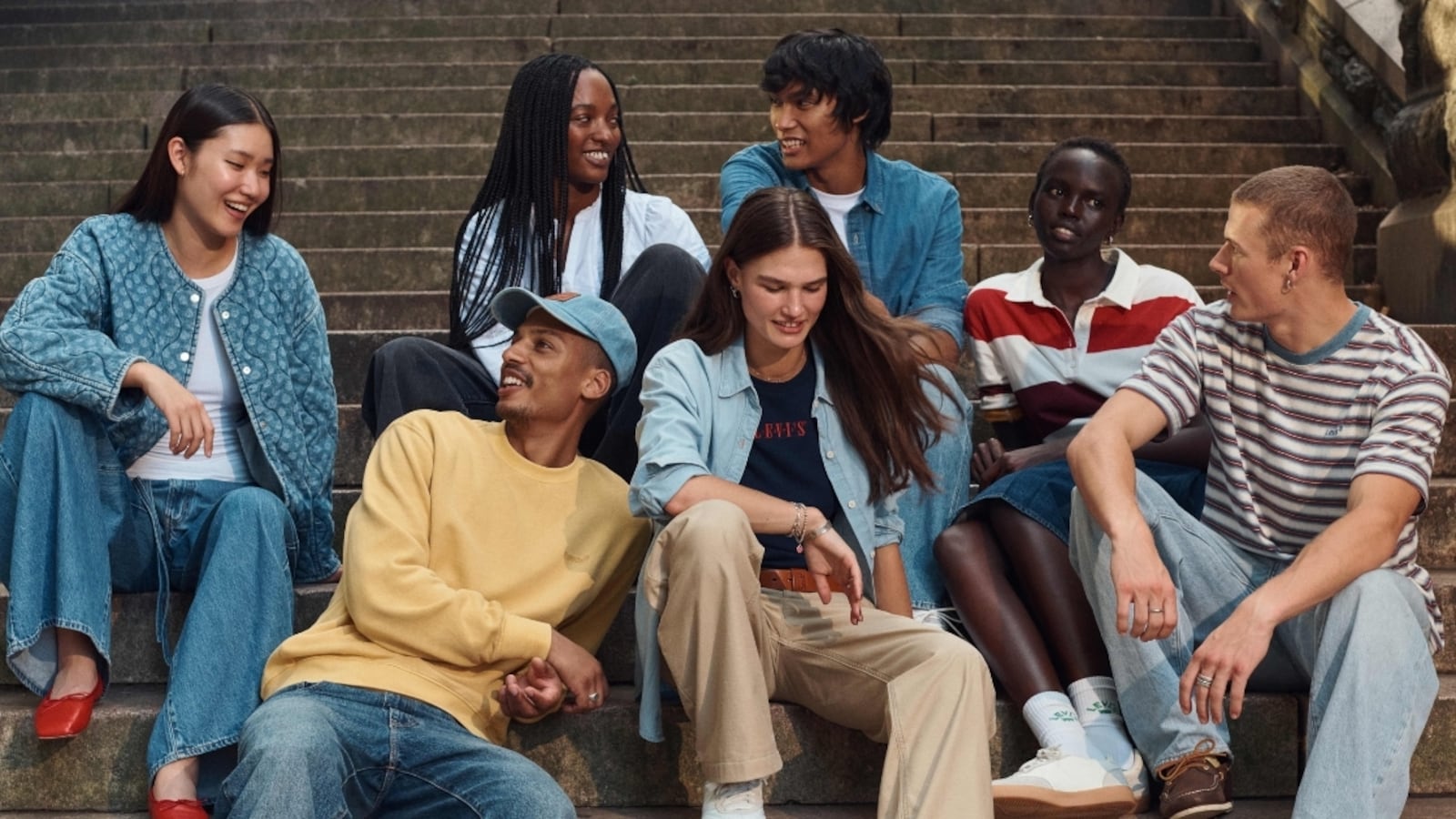 A group of students wearing Levi's clothing, sitting on a staircase.