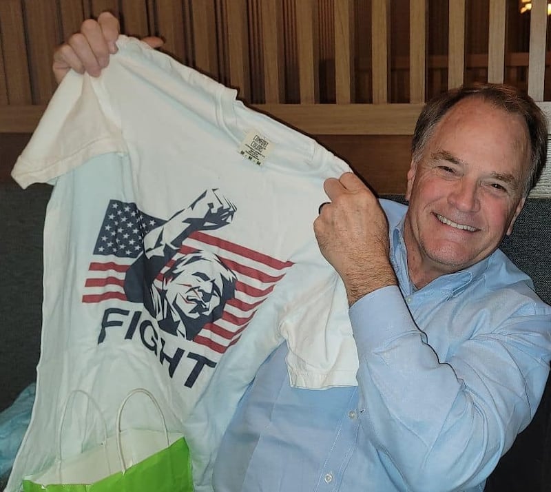 Steve Toth holding a Donald Trump "fight" T-shirt.