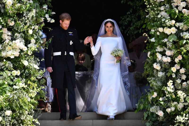 Prince Harry and Meghan Markle walk down the west steps of St. George's Chapel at Windsor Castle on May 19, 2018. Waight designed Markle's sweeping, boatneck Givenchy bridal gown.