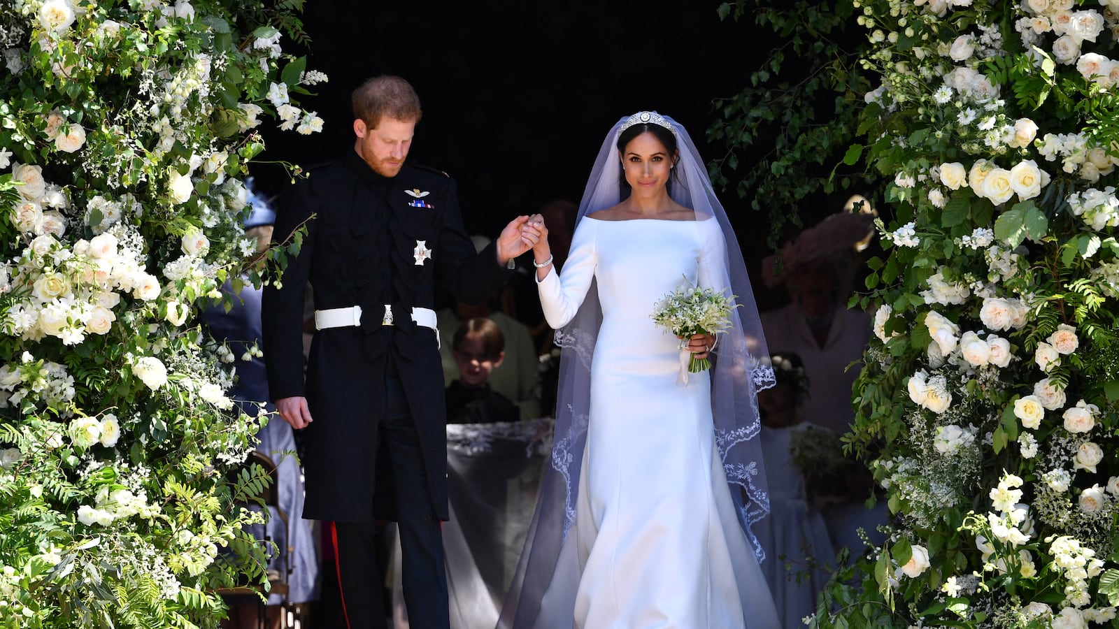 Prince Harry and Meghan Markle walk down the west steps of St. George's Chapel at Windsor Castle on May 19, 2018. Waight designed Markle's sweeping, boatneck Givenchy bridal gown.