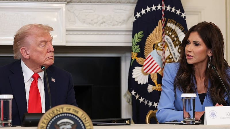 Secretary of Homeland Security Kristi Noem (R) speaks as U.S. President Donald Trump listens during a roundtable discussion in the State Dining Room of the White House on October 08, 2025 in Washington, DC. Trump’s administration held the roundtable to discuss the anti-fascist Antifa movement after signing an executive order designating it as a “domestic terrorist organization”.