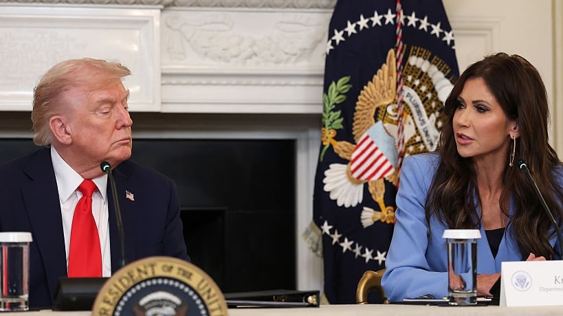 Secretary of Homeland Security Kristi Noem (R) speaks as U.S. President Donald Trump listens during a roundtable discussion in the State Dining Room of the White House on October 08, 2025 in Washington, DC. Trump’s administration held the roundtable to discuss the anti-fascist Antifa movement after signing an executive order designating it as a “domestic terrorist organization”.