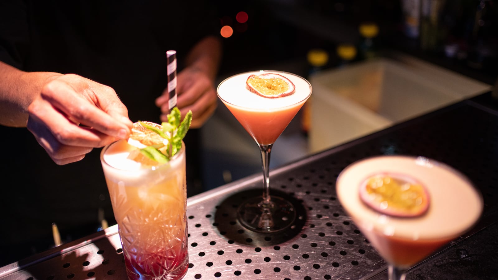 A bartender garnishes a cocktail.
