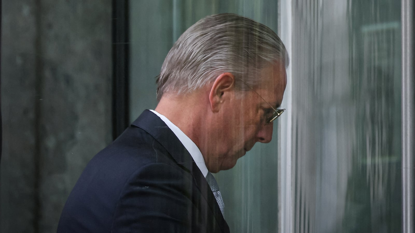 Charles McGonigal walks into a courthouse with his head down on the day he pleaded guilty.
