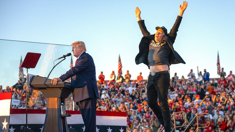 Tesla CEO Elon Musk (R) jumps on stage as he joins Donald Trump during a campaign rally at site of his first assassination attempt in Butler, Pennsylvania on October 5, 2024.