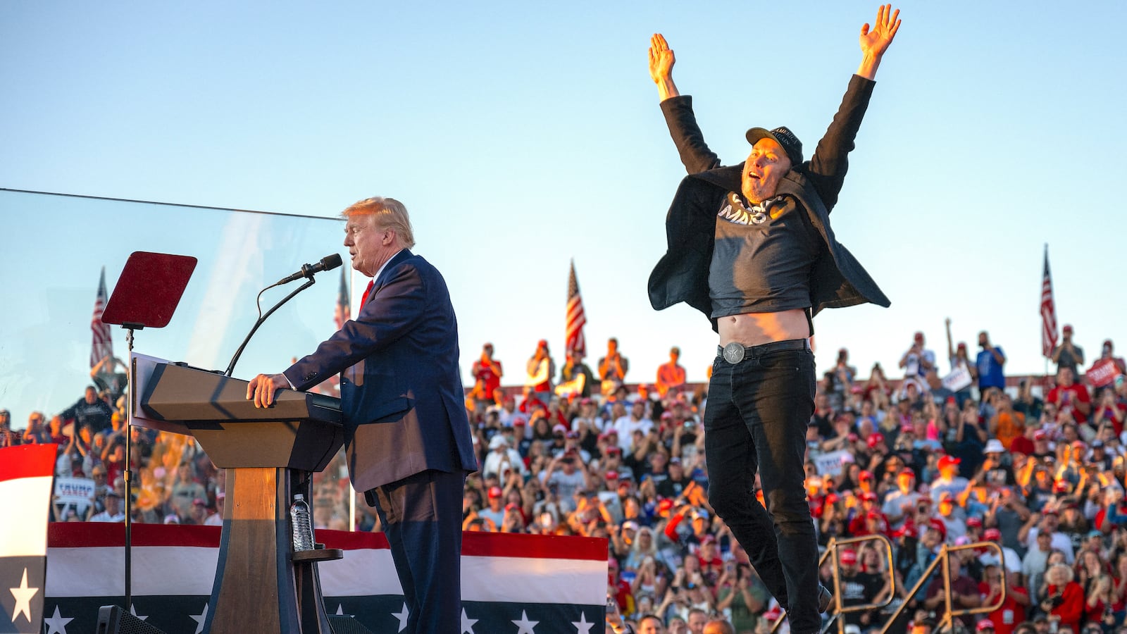 Tesla CEO Elon Musk (R) jumps on stage as he joins Donald Trump during a campaign rally at site of his first assassination attempt in Butler, Pennsylvania on October 5, 2024.