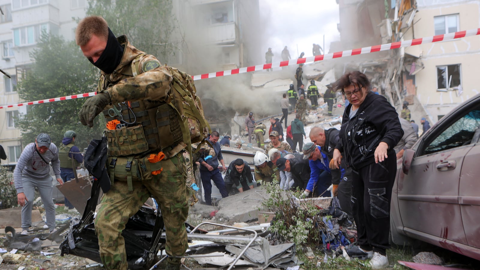 People remove debris while searching for survivors following the collapse of a section of an apartment block in the city of Belgorod, Russia, May 12, 2024.