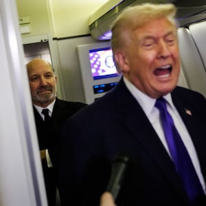 IN FLIGHT - FEBRUARY 06: U.S. Secretary of Commerce Howard Lutnick stands behind U.S. President Donald Trump as he gaggles with reporters while aboard Air Force One on February 6, 2026 en route to Palm Beach, Florida. The President is spending the weekend at Mar-a-Lago, his private club. (Photo by Samuel Corum/Getty Images)