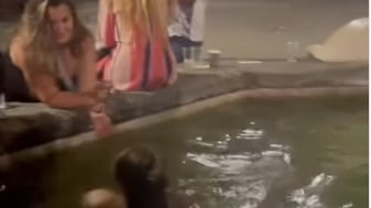 A tourist swims topless in a Florence fountain