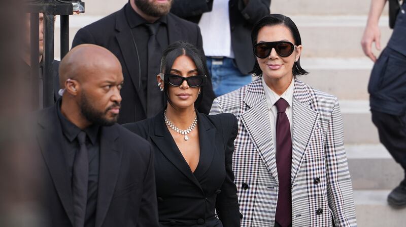 PARIS, FRANCE - MAY 13: Kim Kardashian and Kris Jenner exit the trial at the Palais de Justice ; Kim Kardashian wears sunglasses by Alaia, a black dress with power shoulders / shoulder pads / puff shoulders and low-neck by John Galliano, a necklace by Samer Halimeh, Repossi diamond earcuffs, Brioni Raymond earrings, at the Palais de Justice, on May 13, 2025 in Paris, France. (Photo by Edward Berthelot/GC Images)