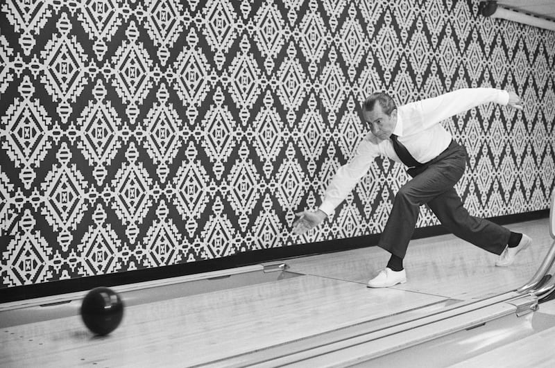 President Nixon is the picture of concentration as he releases bowling ball at Executive Office Building lanes Sept. 17, 1971.