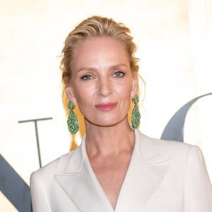 Actress Uma Thurman wearing minimal makeup and a white suit jacket