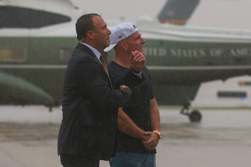 Sports analyst Pat McAfee (R) waits as U.S. President Donald Trump arrives at the Cleveland Hopkins International Airport on August 11, 2026 in Cleveland, Ohio. President Trump is traveling to Ohio to attend the 2026 Patriot Games.
