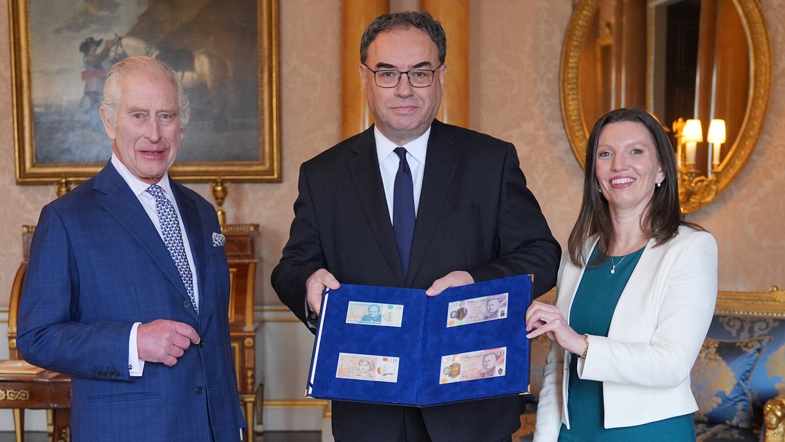 King Charles III (left) is presented with the first bank notes featuring his portrait from the Bank of England.