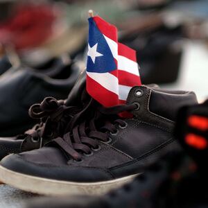 shoes holding puerto rico flag death toll maria katrina counting death statistic demography george washington harvard university climate change global warming